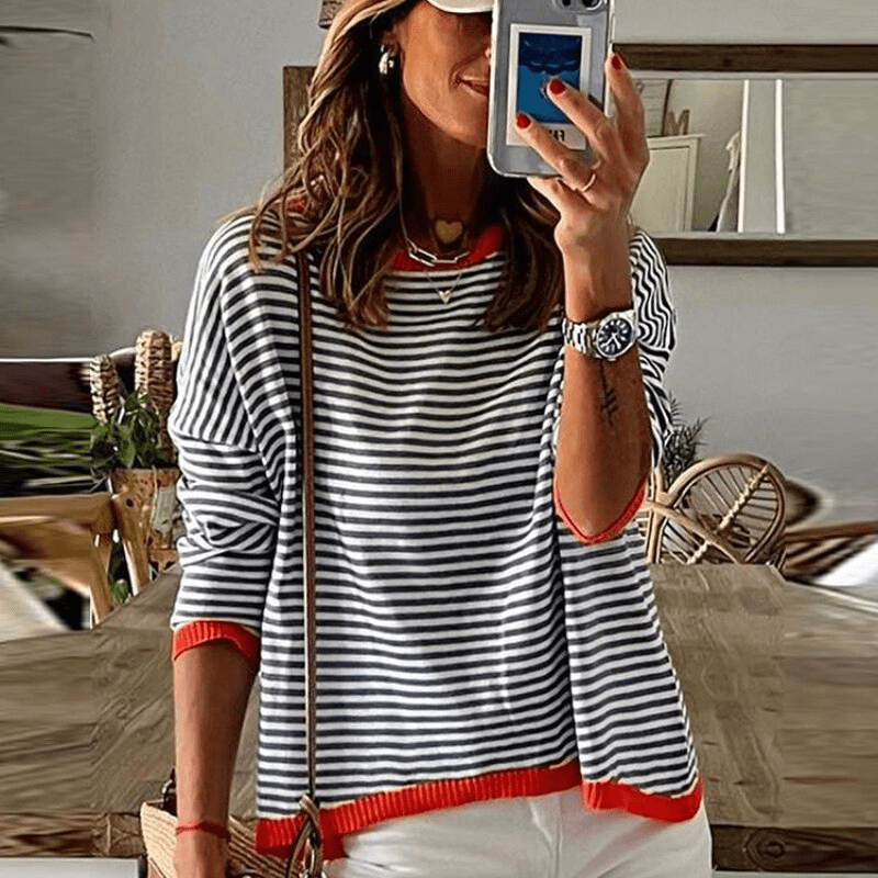 https://cdn.shopify.com/s/files/1/0826/7982/4718/files/ines-lavigne-blau-gestreifter-pullover-mit-orangefarbenem-rand-newberlin-mode-40011953406265.png?v=1715842187